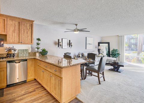 the kitchen and dining room of an apartment with a large window